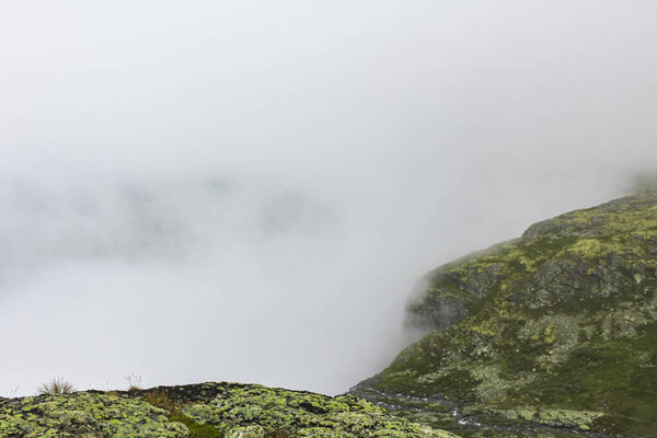 Fog, clouds, rocks and cliffs on Veslehdn Veslehorn mountain in Hemsedal Norway.