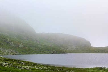 Hemsedal Norveç 'teki Veslehdn Veslehorn dağında sis ve bulutlu büyük kayalar ve uçurumlar.