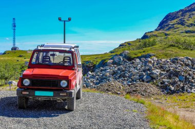 Hemsedal Norveç 'te dağın tepesinde kırmızı 4x4 araç.