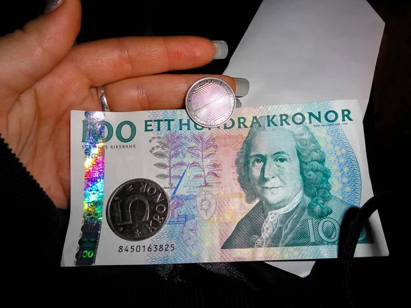 スウェーデンの通貨何百もの紙幣と硬貨が手元にある 暗い背景 — ストック写真