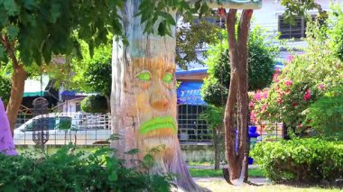 Children park and playground with horror tree with spooky face and swing in the Bueng Kaen Nakhon Public Park Reservoir in Khon Kaen Thailand.