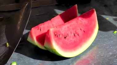 Vendor cuts watermelon on small stall fruits fruits bar stand and street food with glass box in Khon Kaen District Khon Kaen Province Isan Northeast Thailand in Southeast Asia.