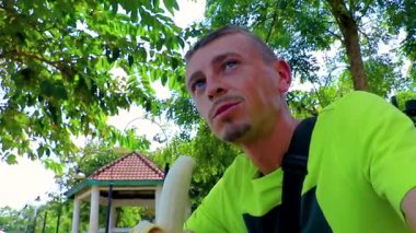Handsome man eats a banana fruit super hungry funny and happy in Khon Kaen District Khon Kaen Province Isan Northeast Thailand in Southeast Asia.