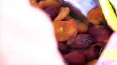 A man eats snack broad beans nuts from a bag at the 7 Eleven store in Khon Kaen District Khon Kaen Province Isan Northeast Thailand in Southeast Asia.