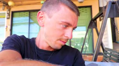 A man eats snack broad beans nuts from a bag at the 7 Eleven store in Khon Kaen District Khon Kaen Province Isan Northeast Thailand in Southeast Asia.