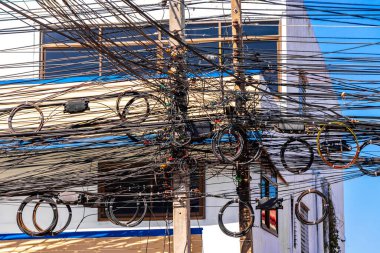 Khon Kaen Eyaleti Isan Tayland 01. Kasım 2018 Güneydoğu Asya 'da Khon Kaen Bölgesi' nde mavi gökyüzü ve güneş ışığı olan bir elektrik direğinde ekstrem kablo düzensizliği..