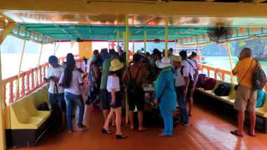 Takua Thung Phang Nga Thailand 12. June 2018 Tourists people on longtail long tail boat boats ship ships green water limestone rocks cliffs mountains at James Bond Island Khao Phing Kan in Thailand.