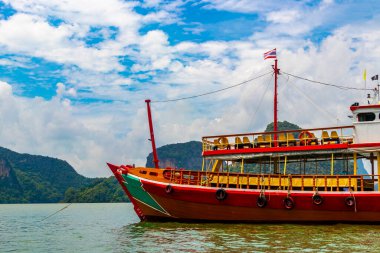 Takua Thung Phang Nga Thailand 12. June 2018 Tourist longtail long tail boat boats ship ships and green water limestone rocks cliffs and mountains at James Bond Island Khao Phing Kan in Thailand.