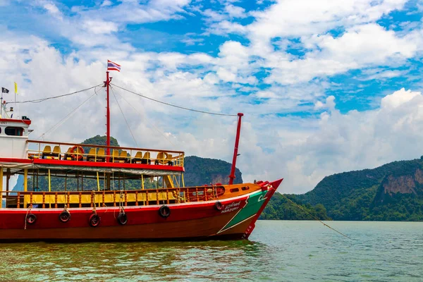 Takua Thung Phang Nga Thailand 12. June 2018 Tourist longtail long tail boat boats ship ships and green water limestone rocks cliffs and mountains at James Bond Island Khao Phing Kan in Thailand.