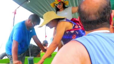 Takua Thung Phang Nga Thailand 12. June 2018 Tourists people changing walking on longtail long tail boat from ship on green water by limestone rocks at James Bond Island Khao Phing Kan in Thailand.