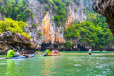 Takua Thung Phang Nga Province Thailand 12. June 2018 Canoe canoes kayak kayaks travel through limestone caves in turquoise green water on Koh Ko Hong Island in Krasom Phang Nga Thailand.