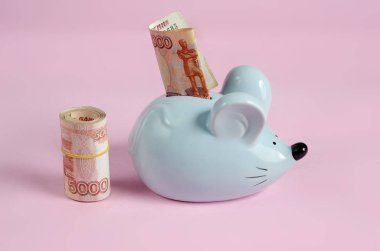 Mavi domuz kumbarası, içinde bir yığın para olan fare şeklinde.