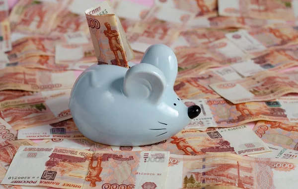 Rus rublesi banknotlarının arka planında fare şeklinde bir kumbara.