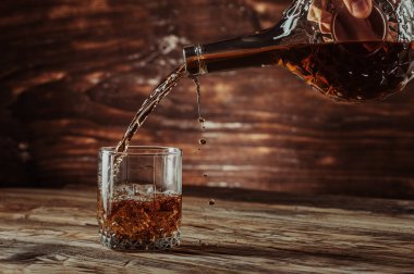 Viski ya da konyak, güzel bir şişeden buzlu bir bardağa doldurulur. Hareketi dondurur. Masanın üstü doğal yaşlandırılmış ahşaptan yapılır.