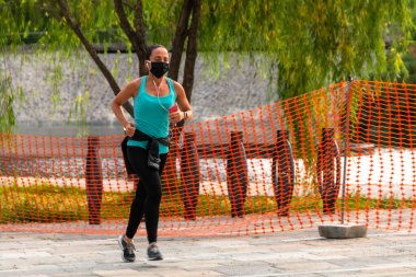 La Mexicana, Santa Fe, Mexico City: 9 Haziran 2020. Karantina boyunca koşu yapan atletik bir kadın. Yeni normallik. cerrahi maske