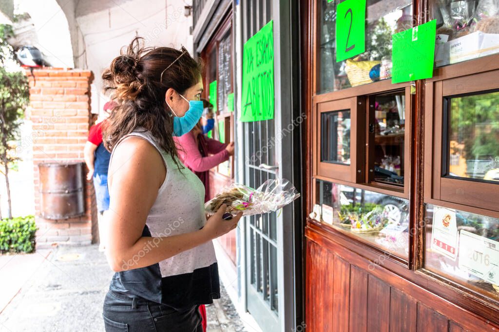 Alvaro Obregon, CDMX. Mexico. June 10, 2020. Woman buys cookies with surgical mask for the new normal. Covid 19