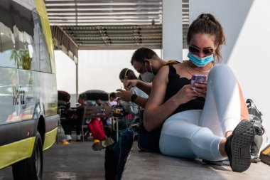 Cancun. Quintanaroo, Meksika. 08.17.2020 Kiralık bir arabanın kendisine teslim edilmesini beklerken koruyucu maske takan gerçek bir kadın. Yeni normal