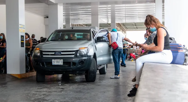 Cancun. Quintanaroo, Meksika. 08.17.2020 Kiralık bir arabanın kendisine teslim edilmesini beklerken koruyucu maske takan gerçek bir kadın. Yeni normal