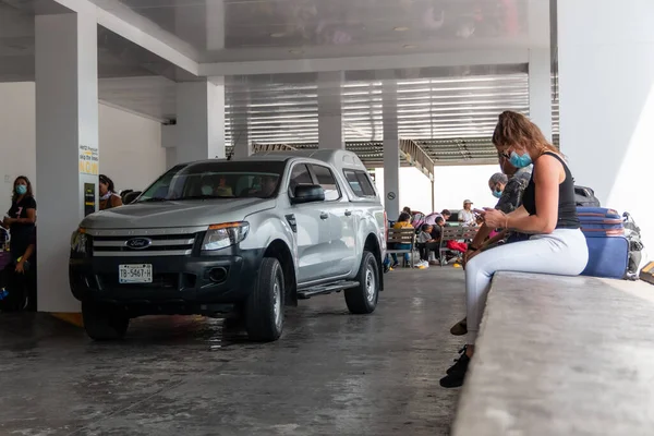 Cancun. Quintanaroo, Meksika. 08.17.2020 Kiralık bir arabanın kendisine teslim edilmesini beklerken koruyucu maske takan gerçek bir kadın. Yeni normal