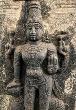 Tanrı, Boğa İlahı heykelini tutuyor. Shiva Tapınağı, Tamil Nadu 'nun taştan duvarlarına oyulmuş kabartma heykel.