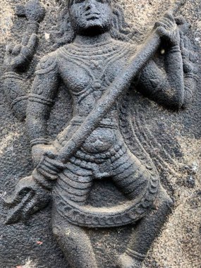 Shiva heykeli trishula tutuyor. Tamil Nadu 'daki Shiva Tapınağı' nın taş duvarına yontulmuş kabartma heykel.