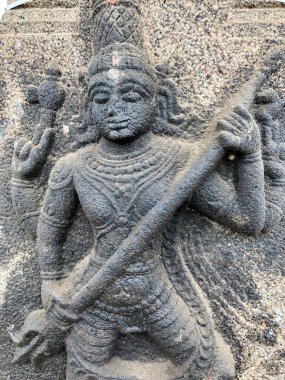 Shiva heykeli trishula tutuyor. Tamil Nadu 'daki Shiva Tapınağı' nın taş duvarına yontulmuş kabartma heykel.