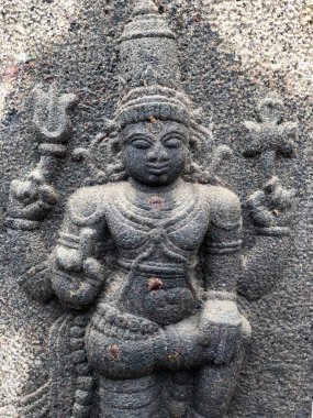 Hindu tanrısı bir bacak heykelinde duruyor. Tamil Nadu 'daki Shiva tapınağının duvarlarına oyulmuş bir heykel.