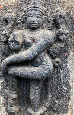 Tanrıça tek bacaklı heykel ile ayakta duruyor. Tamil Nadu 'daki Shiva Tapınağı' nın taş duvarlarına oyulmuş bir heykel.