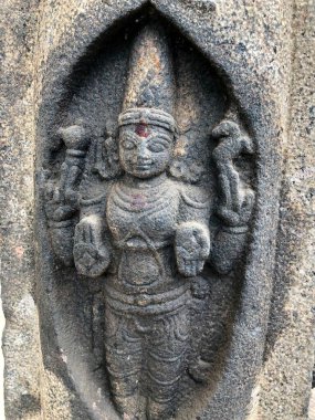 Dört elli Tanrı heykeli. Tamil Nadu 'daki Shiva Tapınağı' nın taş duvarlarına oyulmuş bir heykel.