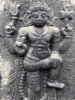 Hindu tanrısı bir bacak heykelinde duruyor. Tamil Nadu 'daki Shiva tapınağının duvarlarına oyulmuş bir heykel.
