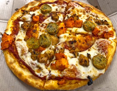 Restoranda servis edilen dilimlenmiş tavuk pizzası.