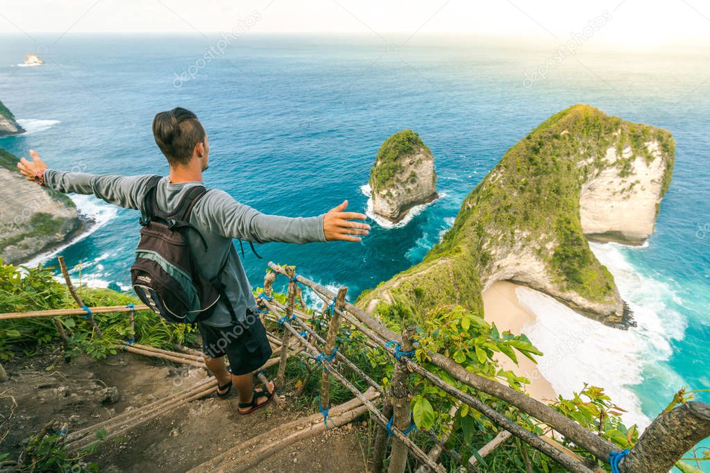 Young Man Standing on the Rock in Nusa Penida Island in Bali, Indonesia. Content: Travel, Adventure, Landscape, Amazing Life, Freedom