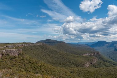 Nsw Avustralya 'da bulutlu bir günde Bushwalker Dağı etrafındaki geniş vadileri yemyeşil ve sık bir orman kaplar.