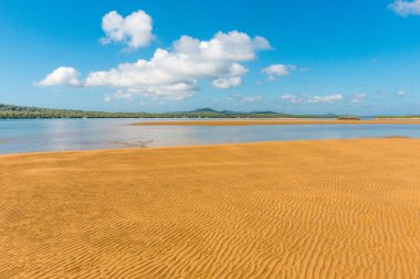İnsanlık tarafından dokunulmamış güzel bir turuncu plaj. Su dalgaları, Queensland Avustralya 'daki Orta Ada' da kumların üzerinde güzel bir desen oluşturur.