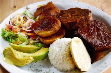 Geleneksel Kolombiya yemekleri. Posta, avokado, arepa, patates, yukka ve salata. 