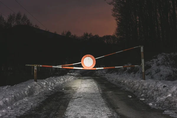 Yol engeli yok araçlar ile fotoğraf gece yolda imzala. Gate bariyer kış orman yolu üzerinde.