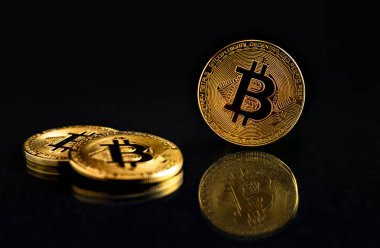 Fotoğraf bitcoins (btc) etkisini yansıtma ile koyu arka plan üzerinde parlayan üç sikke. Yansıması ile siyah arka plan üzerine izole ve ışıklı bitcoins.
