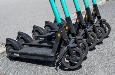 Kiralık elektrikli scooterlar, e-scooterlar, Pavement 'te grup halinde park edilmiş.