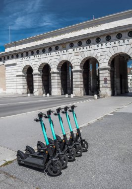 Kiralık elektrikli scooterlar, e-scooter, Viyana 'daki tarihi binanın önünde grup halinde park edilmiş.