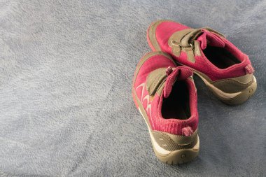 Gri arka planda giyilmiş bir çift spor ayakkabı..