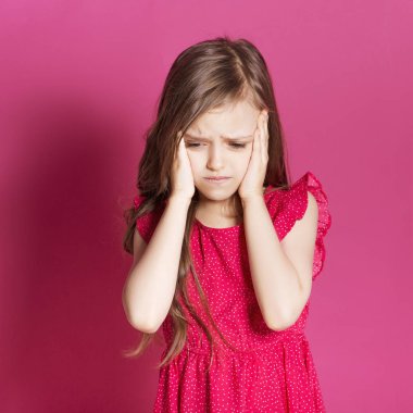 Küçük 8 yaşında kız elleri pembe tarafsız arka plan üzerinde bazı duygusal jest yapmak. O uzun esmer saç ve giyim kırmızı yazlık elbise vardır. Yüzünde komik ifade