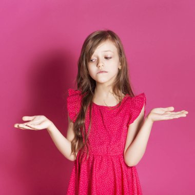 Küçük 8 yaşında kız elleri pembe tarafsız arka plan üzerinde bazı duygusal jest yapmak. O uzun esmer saç ve giyim kırmızı yazlık elbise vardır. Yüzünde komik ifade