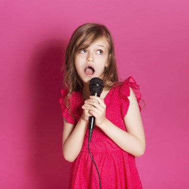 Küçük 8 yaşında kız elleri pembe tarafsız arka plan üzerinde bazı duygusal jest yapmak. O uzun esmer saç ve giyim kırmızı yazlık elbise vardır. Yüzünde komik ifade