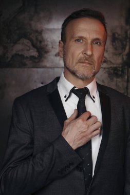 Beyaz gömlek ve kravat grunge koyu arka plan üzerinde eski yakışıklı iş adamı