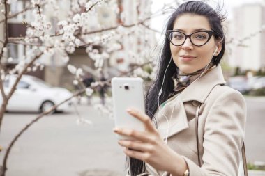 Açık havada ceket, soğuk hava bir sokakta yürüyen kadın. O smartphone becerikli alet için bir iş (iş), serbest çalışan olarak office dışında bir proje üzerinde kullanın. Alan, alan için metin kopyalama