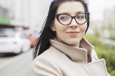 Kent parkta bir yürüyüş üzerinde uzun siyah saçlı kadın. O bir klasik giyer (ya da rahat akıllı) kat soğuk rüzgarlı havalarda. Kopya alanı