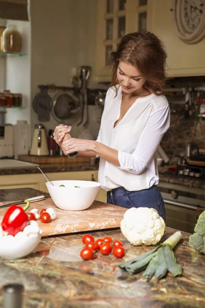 Gündelik kıyafeti evinde mutfakta yemek güzel genç esmer kadın. Lüks zengin iç