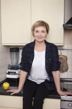 Yaşlı kadın evinde mutfak pişirme. Casual kıyafet. Portre iç.