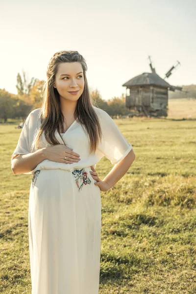 Morena Linda Mujer Embarazada Vestido Blanco Campo Con Molino Madera —  Fotos de Stock