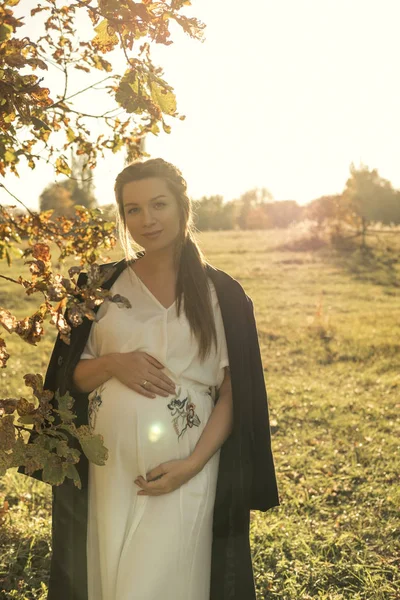ドレスと秋の寒い公園で散歩のコートかわいい白人妊婦 — ストック写真